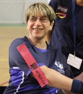 Jay Anderson smiling towards the camera in her Scotland wheelchair rugby top 