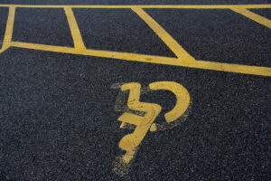 iStock 1361867199 Yellow street information sign painted on the road surface with lines marking the reserved parking zone for disabled drivers.