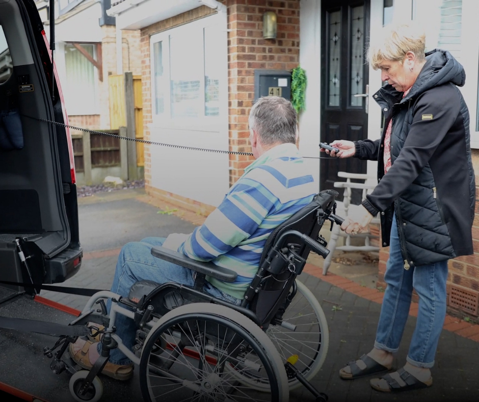 Joanne helps Chris up the ramp and into to WAV with help from the electric-assist winch.