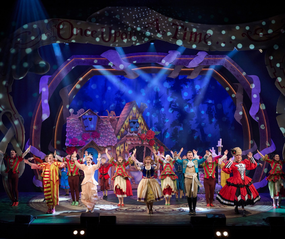 Stage performance of Snow White panto taking place at the empire theatre i Eden Hight courts in Inverness. Theatrical cast in colorful fairy tale costumes bows on stage, with a whimsical cottage backdrop and 'Once Upon a Time' sign above, under dramatic stage lighting. Image Credit: Imagine Theatre & Eden High Courts Page.