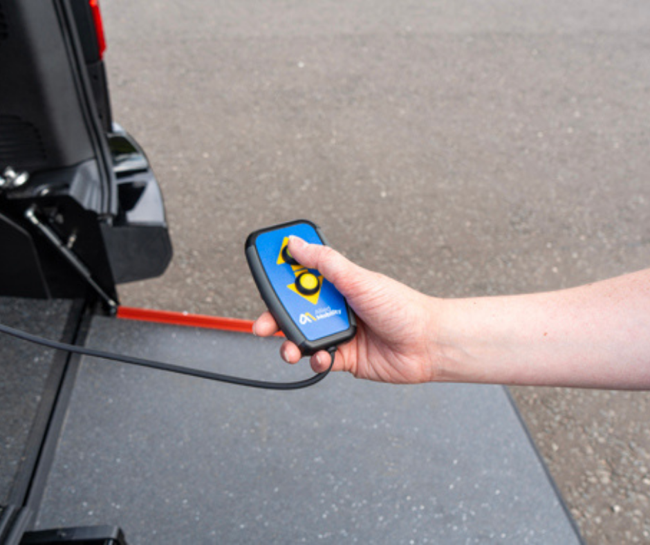 Hand using a remote control electric-assist winch to help guide the wheelchair user in and out of the WAV.