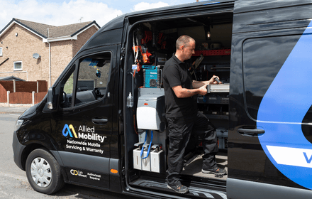 Allied Mobility service van with side door open, showing a technician inside grabbing equippment.
